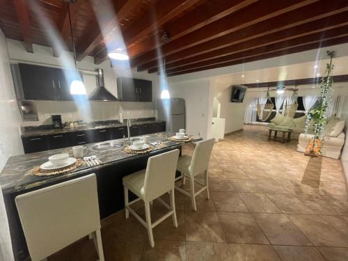 a kitchen and living room with a table and chairs at Beachfront Bungalow Rosarito Beach in Rosarito