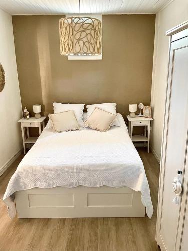 - une chambre avec un grand lit blanc et deux tables de chevet dans l'établissement Magnifique appartement au cœur du centre ville, à Sète