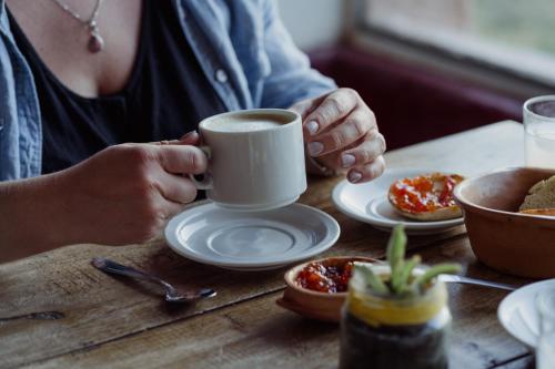 a person sitting at a table with a cup of coffee at Sala de Payogasta in Payogasta
