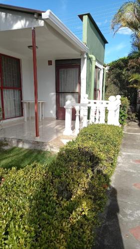 a white house with a fence in front of it at Precioso alojamiento con 6 piscinas en conjunto cerrado in Espinal