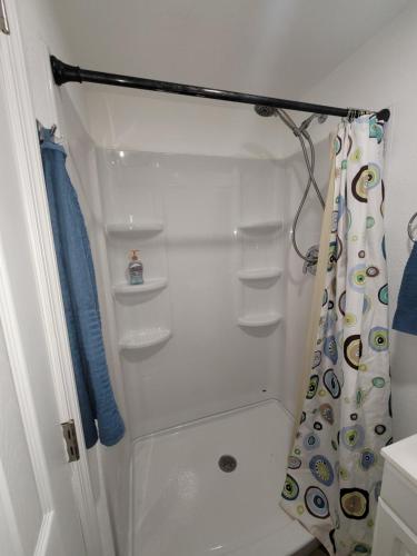 y baño con ducha y cortina de ducha. en Cozy studio apt en Orlando