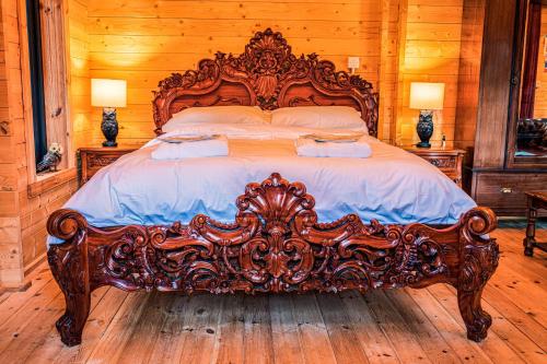 a large wooden bed in a bedroom with wooden floors at Haw thorn Hideaway in Doncaster