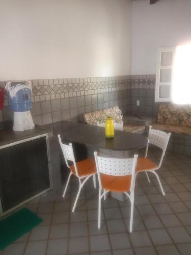 a kitchen with a table and chairs with a yellow candle on it at Pé de mato chalé in Estância
