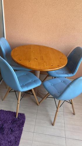a wooden table with two blue chairs around it at Happy Time 1 in Petroşani