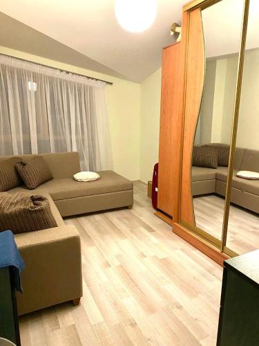 sala de estar con sofá y espejo grande en Dainiaus Apartamentai, en Palanga