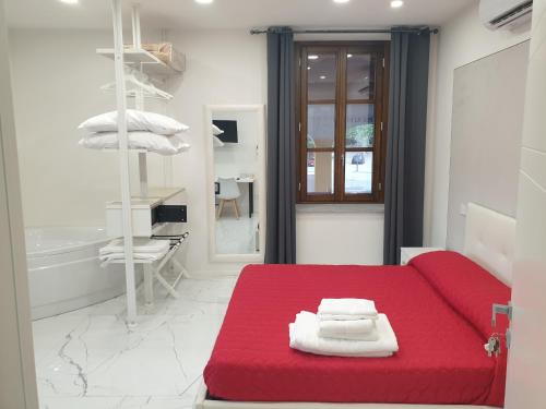 Sofá rojo en una habitación blanca con almohadas en Cafe del peso, en Cavour