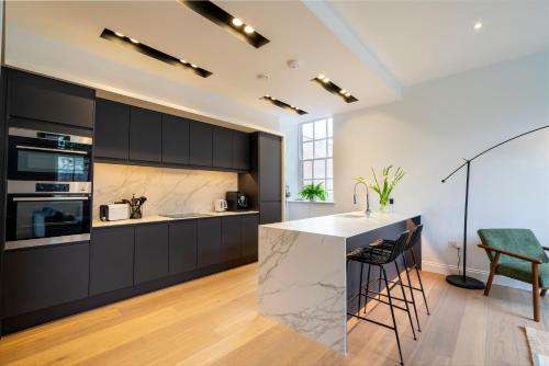 a kitchen with black cabinets and a white counter top at Marygate - Museum Apartment in York