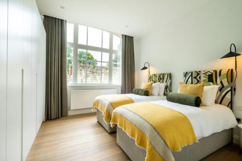 a bedroom with two beds and a window at Marygate - Museum Apartment in York
