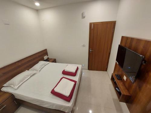 małą sypialnię z łóżkiem i telewizorem z płaskim ekranem w obiekcie FOUR SQUARE COMFORTS w mieście Manipala