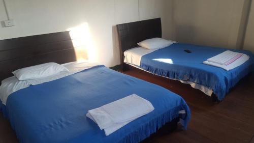 2 camas en una habitación de color azul y blanco en Hotel San Agustín, en San Agustín