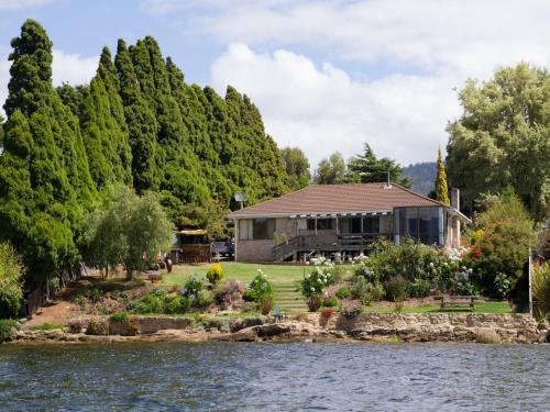 a house on the shore of a lake with trees at Derwent Vista in Austins Ferry