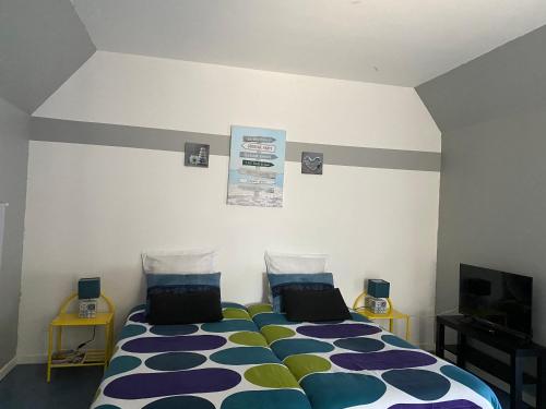 a bedroom with a bed with a colorful comforter at Studio à Vierville-sur- mer(plage du Débarquement) in Vierville-sur-Mer