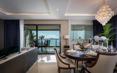 a dining room with a table and chairs with a view at The Elysium Prațumnak Pattaya - By SHG in Pattaya South