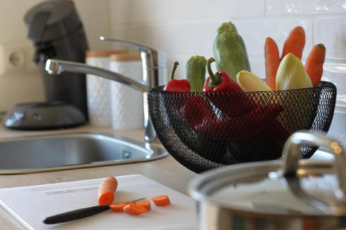 a bowl of vegetables sitting on a counter next to a sink at Vulkan-Nest in der Eifel in Ulmen
