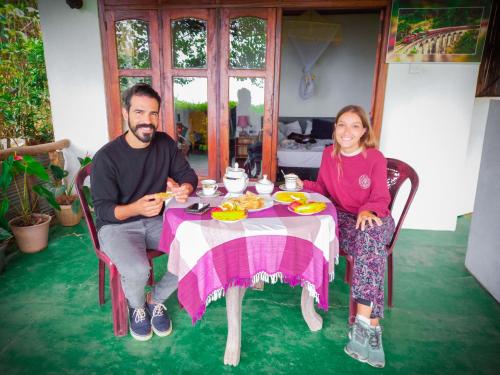 a man and a woman sitting at a table at Ella Happy View Homestay in Ella
