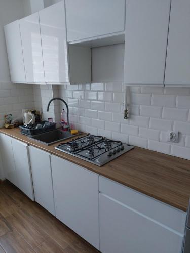 a white kitchen with a stove and a sink at Apartament Chopina 17 in Włocławek