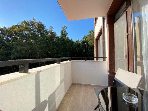 a balcony with a glass table and a window at The Green Paradise Apartments in Primorsko