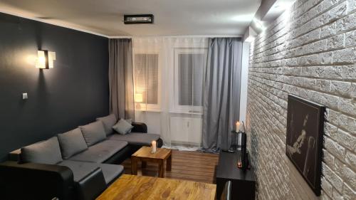 un salon avec un canapé et un mur de briques dans l'établissement Mieszkanie Przy Deptaku, à Świnoujście