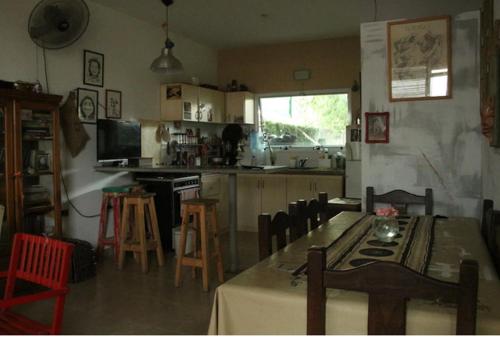 cocina con mesa y sillas y cocina con encimera en Habitaciones en casa encantada para viajeros en Gualeguaychú