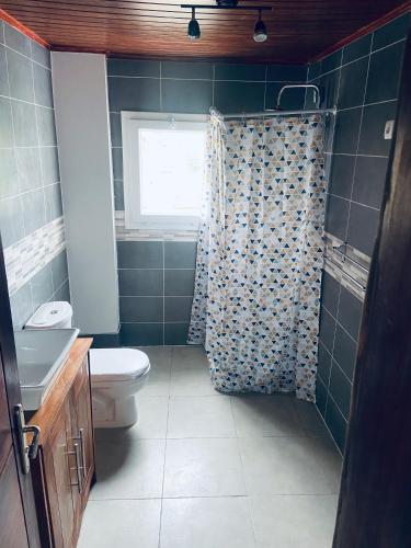 a bathroom with a toilet and a window and a shower at Résidence Le Vieux Lyon Après collège père monti in Yaoundé