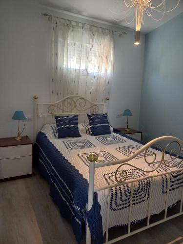 1 dormitorio con 1 cama grande con almohadas azules en Casa Los Granainos, en Albaida del Aljarafe