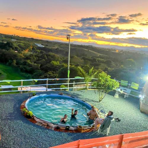a group of people sitting in a swimming pool at CAMPING LOS ROBLES POPAYÁN in Florencia