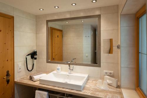 ein Bad mit einem Waschbecken und einem Spiegel in der Unterkunft Landhaus Marion in Holzgau