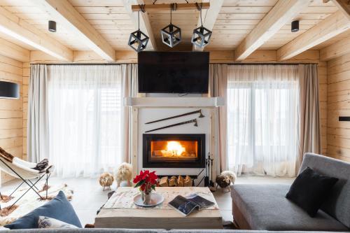 a living room with a fireplace and a couch at Osada Chłabówka Zakopane & SPA in Zakopane