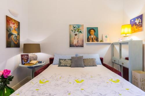 a bedroom with a bed and some pictures on the wall at Casa Parravano in Caserta