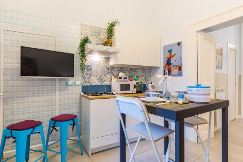 a kitchen with a table and stools in a room at Casa Parravano in Caserta