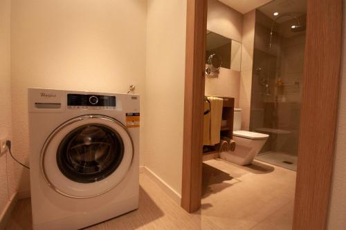 a washing machine in a bathroom with a toilet at Superior 2 bedroom penthouse, almost on the beach. in Mogán