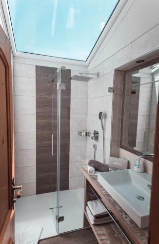 a bathroom with a glass shower and a sink at Landhaus Marion in Holzgau