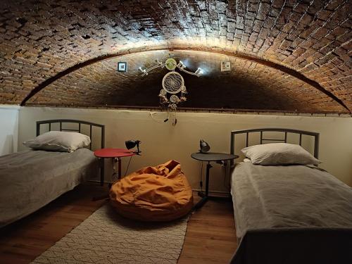 a bedroom with two beds and a brick wall at Downtown Studio in Oradea