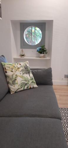 - un canapé avec un oreiller dans une chambre avec une fenêtre dans l'établissement Appart Saint Cyprien + Parking privatif, à Poitiers