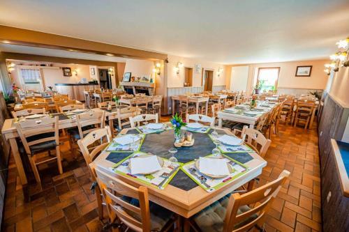 une grande salle à manger avec tables et chaises dans l'établissement Chalet Aster 3 étoiles, à Arrentès-de-Corcieux