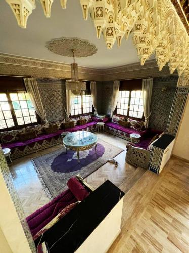 sala de estar con muebles de color púrpura y lámpara de araña en Beautiful Villa Casablanca en Casablanca