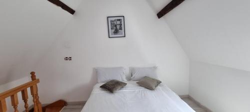 1 dormitorio con 1 cama blanca y 2 almohadas en Maison de Luxe Centre ville avec 6 lits et Garage, en Valenciennes