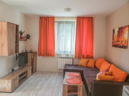 a living room with a couch and red curtains at Lovely Borovets Apartment in Borovets