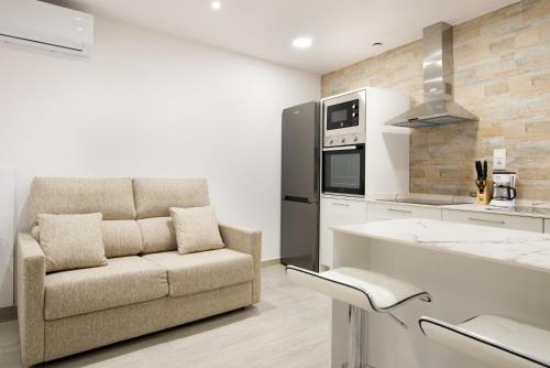 een keuken met een bank en een fornuis top oven bij Apartamentos La Jasa in Arguedas
