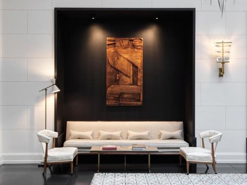 a living room with a couch and a painting on the wall at J.K. Place Roma - The Leading Hotels of the World in Rome