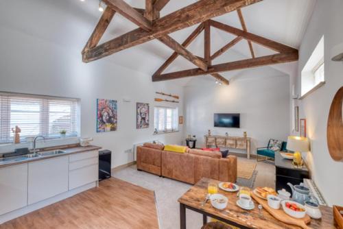 een keuken en een woonkamer met een tafel en een bank bij Gorgeous 1-bed city apartment, sleeps 4 in Worcester