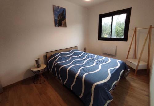 a bedroom with a bed with a blue and white blanket at Villa Jade in Sartène