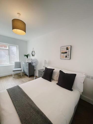 a bedroom with a large white bed and a desk at Pearl House - Delightful 3-4 Bedroom Coastal Getaway in Gorleston-on-Sea