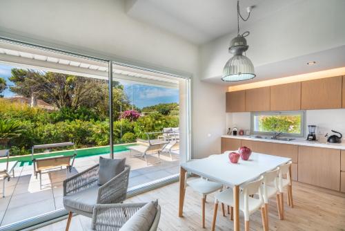 een keuken en eetkamer met uitzicht op een zwembad bij Villa Kòsmos - Piscina e Giardino - Villasimius in Simius