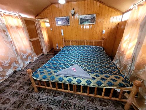 Tashkand Houseboat في سريناغار: غرفة نوم بسرير في غرفة خشبية