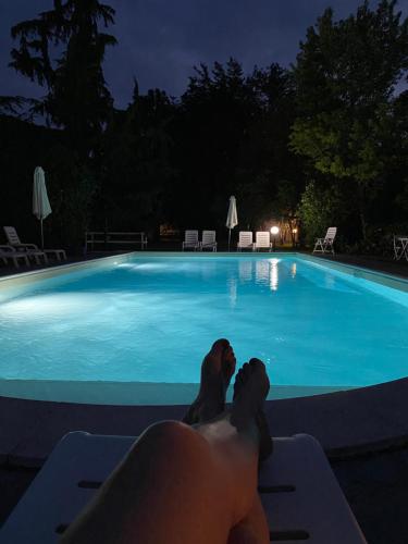 a person laying on a chair in front of a swimming pool at B&B La Terrazza in Pozzolengo