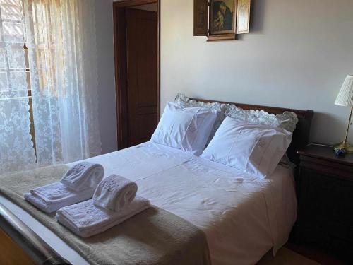 a bedroom with a bed with towels on it at Casa dos Laceiras in Sandim