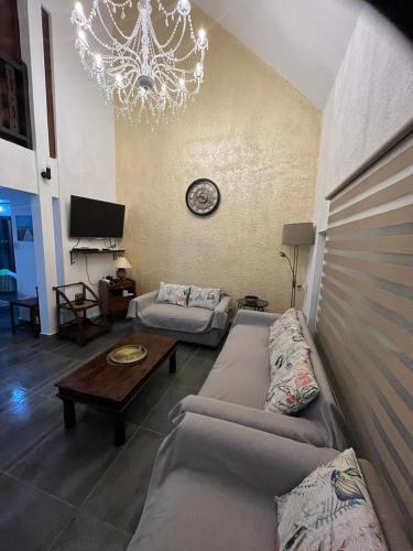 a living room with two couches and a chandelier at Villa Tourelle of Paradise with bigPrivate Pool in Rivière Noire