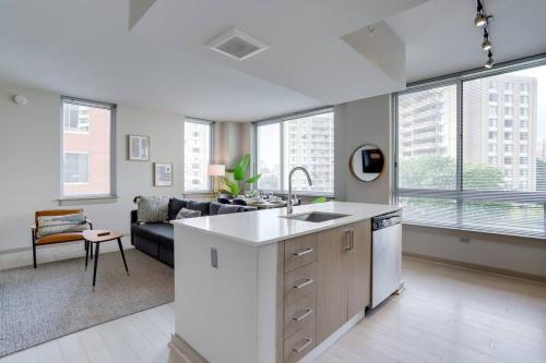 an open kitchen and living room with a couch at Stylish Condo at Crystal City With Rooftop in Arlington