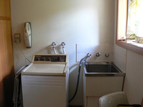 une petite cuisine avec un évier et un téléphone dans l'établissement Derwent Retreat, à Austins Ferry